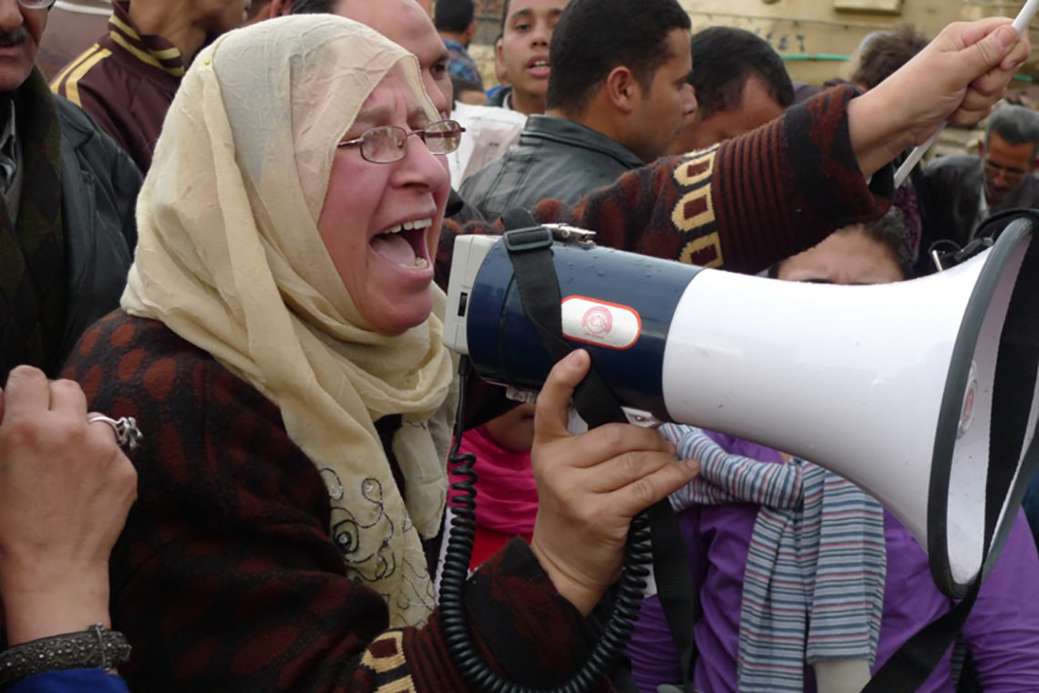 A woman leads chants through a non-functioning megaphone in Tahrir Square near the Egyptian Museum