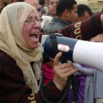 A woman leads chants through a non-functioning megaphone in Tahrir Square near the Egyptian Museum