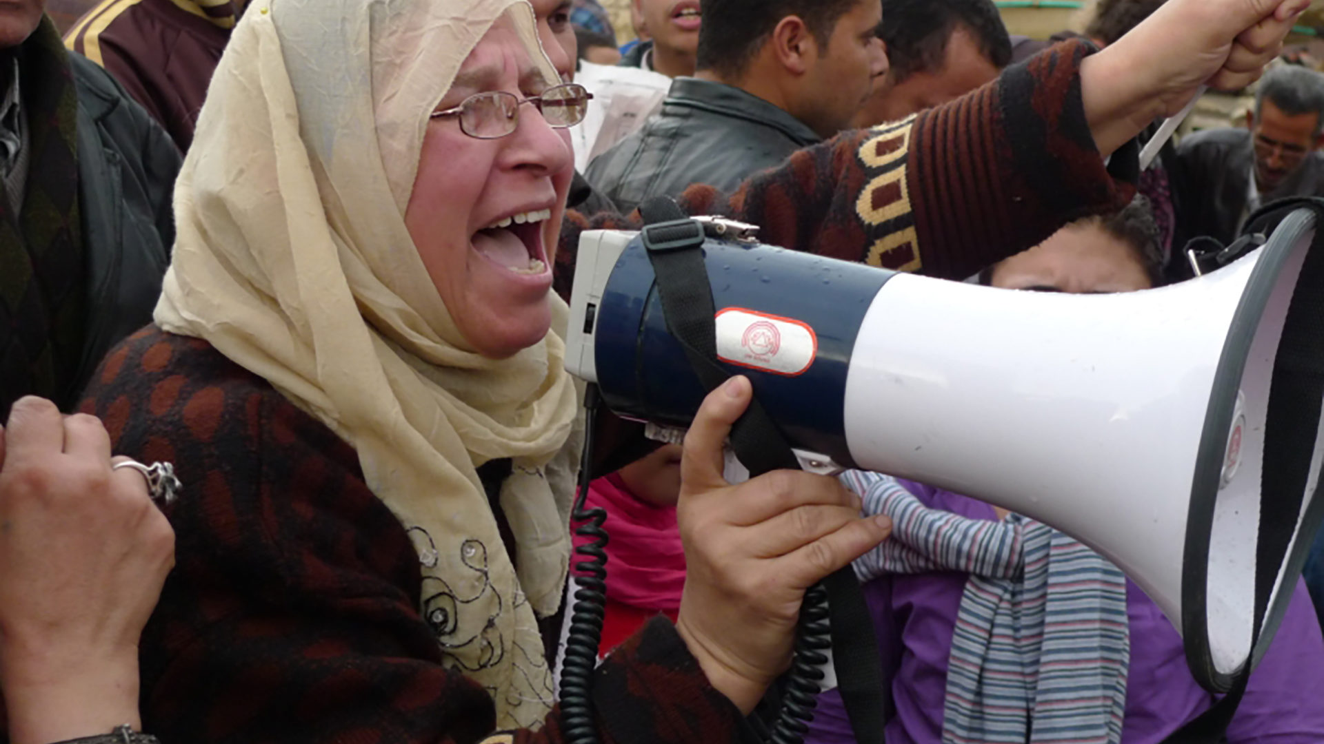 A woman leads chants through a non-functioning megaphone in Tahrir Square near the Egyptian Museum